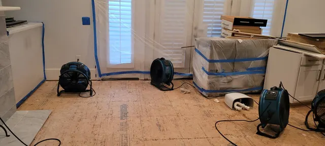 Air movers across exposed subfloor during structural drying