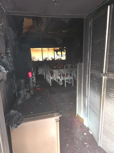 Fire-damaged interior documented from an entry corridor