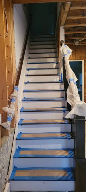 Stairway with treads and railings masked and protected during work