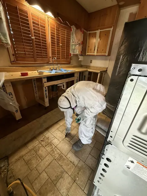 Technician in protective equipment working within containment