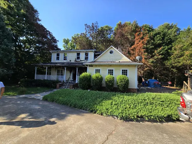 Two-story home with upper-floor fire damage documented from the exterior